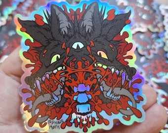May include: A holographic sticker featuring a dark, multi-eyed wolf creature with sharp teeth and a central spinal column graphic. The design incorporates vibrant red splatters and a reflective finish. The text @PHASE MOTH is printed in the corner.