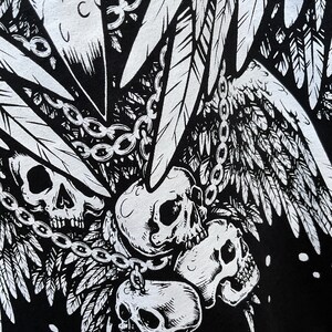 Peut inclure: Design graphique noir et blanc repr&eacute;sentant quatre cr&acirc;nes avec des ailes et des cha&icirc;nes. Les cr&acirc;nes sont finement d&eacute;taill&eacute;s et ont une esth&eacute;tique gothique.
