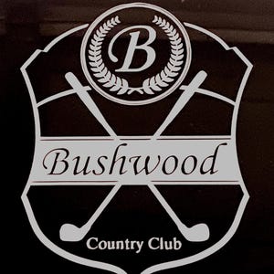 May include: A white vinyl decal featuring a shield-shaped emblem with a central letter B inside a laurel wreath. Two crossed golf clubs are positioned behind a horizontal banner displaying the text Bushwood, with Country Club below.