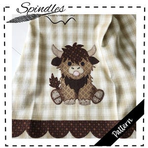 Könnte beinhalten: Ein karierter Stoff in Beige und Weiß mit einem braunen, gewellten Rand. Ein Patchwork-Applikation einer Highland-Kuh in Braun- und Beigetönen ist auf dem Stoff zentriert. Das Wort "Spindles" steht oben, und "Pattern" auf einem schwarzen Banner.