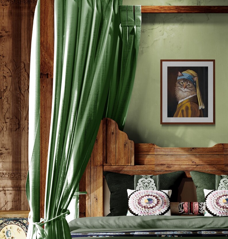 May include: A framed print of a cat in the style of Johannes Vermeer's "Girl with a Pearl Earring" hangs on a green wall. The cat wears a blue headscarf and a yellow and brown outfit. The bed has green pillows and a wooden headboard.