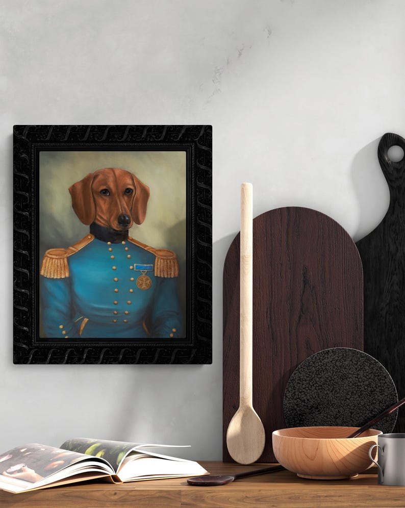 Pu&ograve; includere: Ritratto incorniciato di un bassotto in uniforme militare blu con spalline dorate e una medaglia. Il cane ha il pelo marrone ed &egrave; ambientato su uno sfondo morbido e neutro. La cornice &egrave; nera e ornata.