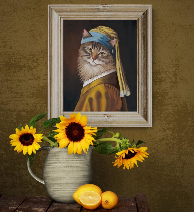 May include: A framed painting of a cat in the style of Vermeer's "Girl with a Pearl Earring." The cat wears a blue headscarf and a yellow and brown outfit. Sunflowers in a gray pitcher and lemons sit on a wooden table.
