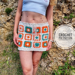 May include: A crochet mini skirt with a drawstring waist. The skirt features a repeating pattern of orange and teal squares, bordered by white crochet. The text "CROCHET PDF PATTERN" is in a circle in the image.