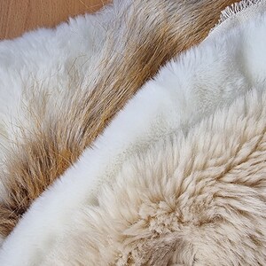 May include: Two pieces of faux fur fabric. One is a light brown color and the other is a white color.
