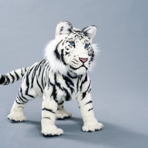 May include: A white stuffed tiger with black stripes. The tiger has blue eyes and a fluffy white mane.
