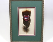 Purple Raccoon Bandit Hand Painted on Mississippi Wild Turkey Feather. Framed in Shadowbox. Matted with Moss Green and Purple.