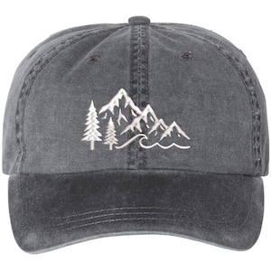 May include: A black denim baseball cap with an embroidered design of a mountain range with trees and a wave. The design is in white.