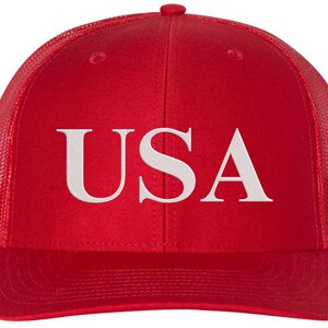 Pode incluir: Bon&eacute; de caminhoneiro de malha vermelha e preta com um "USA" bordado em branco na frente.