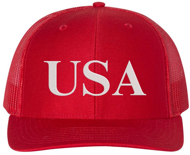 Pode incluir: Bon&eacute; de caminhoneiro de malha vermelha e preta com um "USA" bordado em branco na frente.