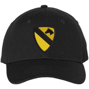 May include: A black baseball cap with a yellow and black embroidered patch featuring a horse's head. The patch is the insignia of the 1st Cavalry Division.