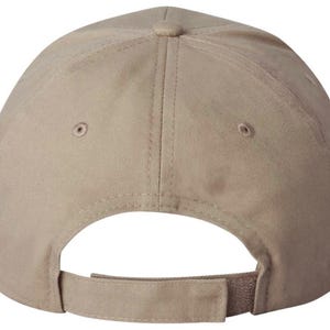 May include: A tan baseball cap, seen from the rear, with an adjustable strap and curved peak. The cap features a classic six-panel design, a button at the crown, and two small ventilation holes on each side.