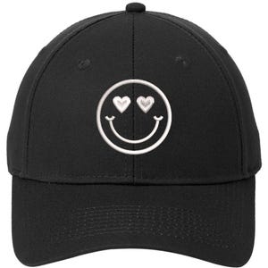 May include: A black baseball cap with a white embroidered smiley face with heart eyes.