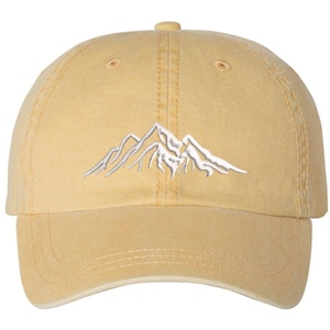 May include: A yellow baseball cap with a white embroidered mountain design.