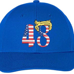 May include: Royal blue baseball cap with the number "48" embroidered on the front. The "4" is designed with the American flag, and the "8" features a gold-coloured hair design.