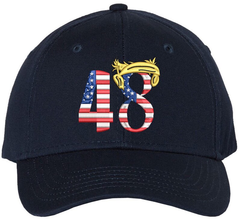 May include: A navy blue baseball cap featuring the embroidered number "48" on the front. The numbers are designed with the American flag pattern. Above the number "8" is a gold-colored design.