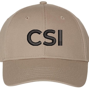 May include: A tan baseball cap with black embroidered text that reads "CSI".