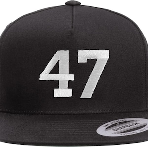 May include: Black snapback hat with the number "47" embroidered in white on the front. The hat has a flat brim and a snap closure at the back. The hat is a classic style, suitable for casual wear.