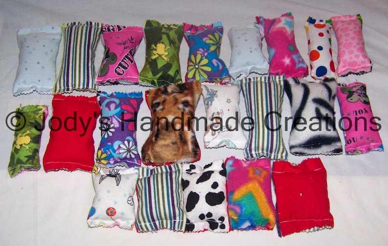 Pu&ograve; includere: Una collezione di 18 giocattoli per gatti in tessuto con erba gatta a forma di cuscino. I giocattoli sono realizzati in vari tessuti, tra cui strisce, pois e motivi floreali. I giocattoli sono tutti lunghi circa 13 cm e larghi 5 cm.
