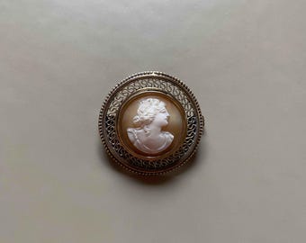 Broche victoriano con camafeo de concha, marco redondo ornamentado, siglo XIX, joyería antigua, pieza de colección.