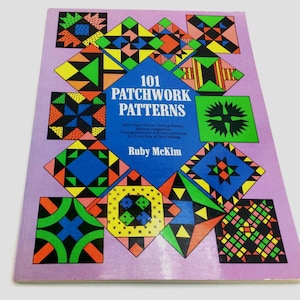 May include: A book titled "101 Patchwork Patterns" by Ruby McKim. The cover features a lavender background with colorful patchwork quilt block designs in various shapes and colors, including blue, green, orange, and yellow. The title is in white and the book is slightly angled.