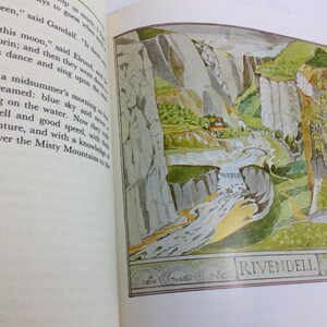 May include: A book page featuring a colorful illustration of a landscape with mountains, a river, and a small building. The word "RIVENDELL" is written at the bottom of the image. The opposite page contains printed text.