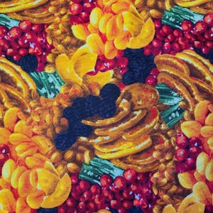 Puede incluir: Un patrón de tela que presenta una disposición densa de rodajas de albaricoque amarillo, racimos de pequeñas bayas rojas y moras azul oscuro intercaladas con hojas verdes. El diseño crea un motivo repetitivo y colorido de frutas.