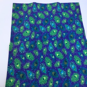 May include: A fabric with a repeating pattern of peacock feathers in shades of green, blue, and yellow on a dark purple background. The feathers are detailed with eye-like patterns.