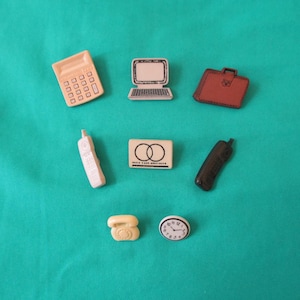 May include: A collection of miniature office supplies, including a calculator, laptop, briefcase, cell phones, a credit card, a landline phone, and a clock. The items are in various colors, set against a teal background.