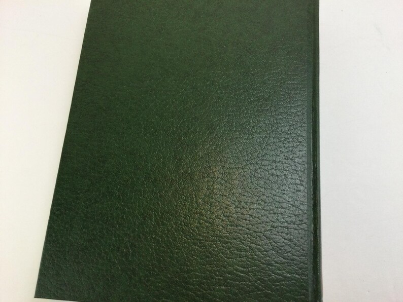 May include: A dark green book cover with a textured, leather-like appearance. The cover is rectangular and appears to be part of a bound book. The edges are smooth and the overall aesthetic is classic and simple.