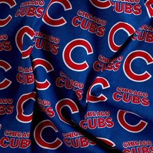 May include: Blue fabric with a repeating pattern of the Chicago Cubs logo. The logo is red and white and features the letter "C" and the words "Chicago Cubs".