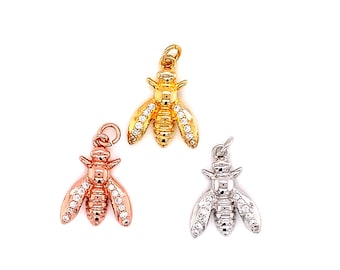 May include: Three bee charms with clear crystal accents. The charms are in gold, rose gold, and silver.
