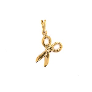 May include: A gold-coloured pendant charm in the shape of a pair of scissors.