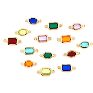 May include: Assortment of colorful glass connector charms with gold metal frames. The charms are in various shapes, including oval, rectangle, and square.