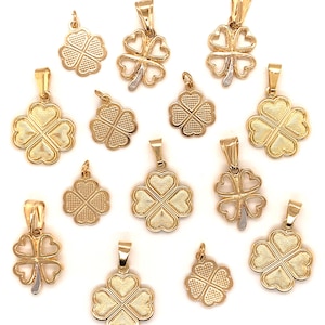 May include: A collection of 13 gold four-leaf clover charms. The charms are all different sizes and styles, some with a textured finish and some with a smooth finish. Some of the charms have a two-tone design with a gold and white finish.