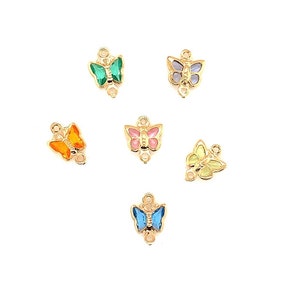 May include: Six gold butterfly charms with colorful enamel accents. The butterflies are in shades of green, blue, pink, orange, and yellow.