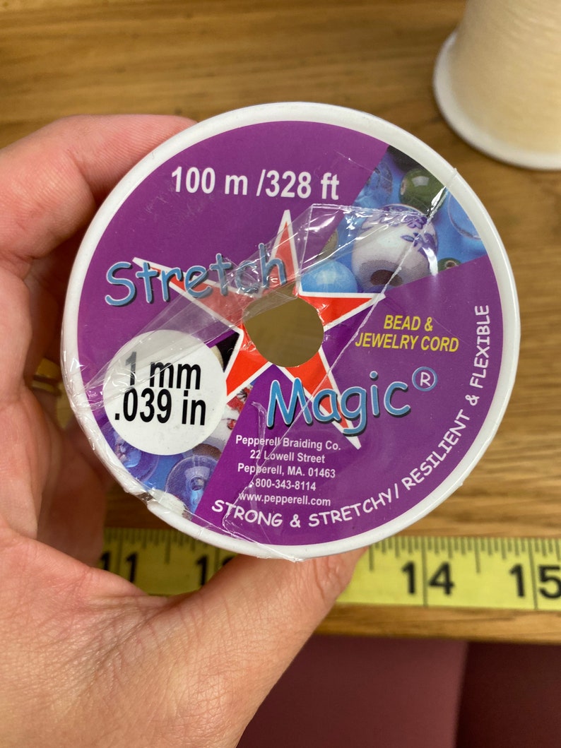 Puede incluir: Un carrete de cord&oacute;n Stretch Magic para cuentas y joyer&iacute;a. La etiqueta morada y blanca indica que el cord&oacute;n tiene 1 mm de di&aacute;metro y 100 metros de largo. La etiqueta tambi&eacute;n indica que el cord&oacute;n es fuerte, el&aacute;stico, resistente y flexible.