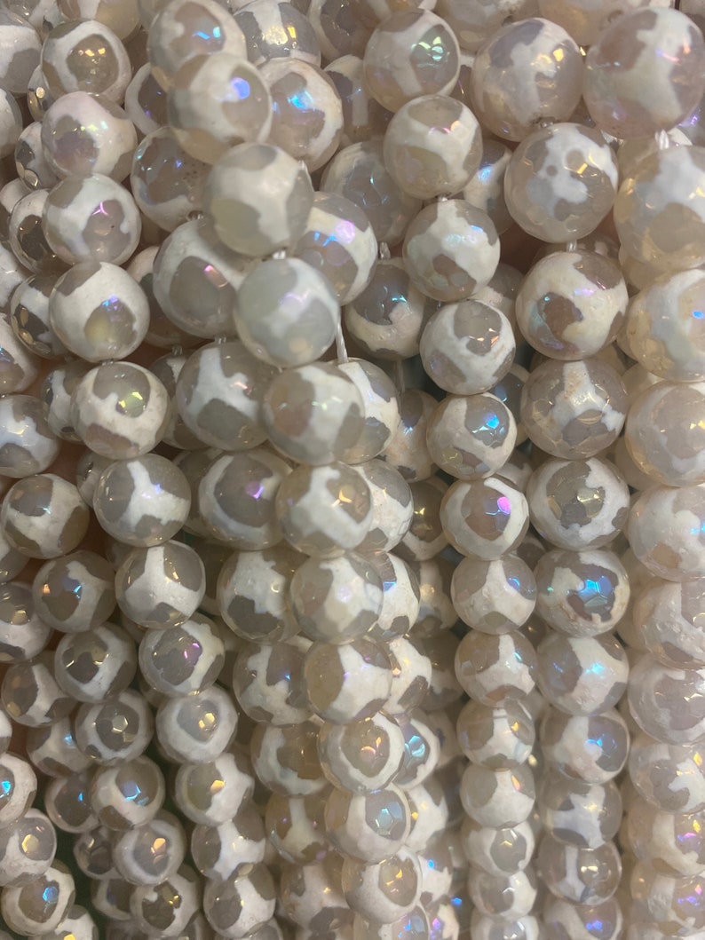 May include: A strand of white agate beads with iridescent shimmer. The beads are round and have a natural, organic look.