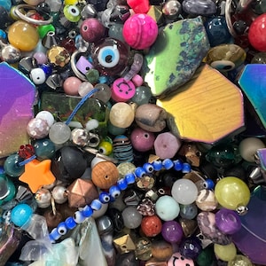 May include: A large assortment of colorful beads, charms, and other jewelry making supplies. The beads are made of various materials, including glass, metal, and stone. There are also a variety of shapes and sizes, including round, square, and star-shaped beads. The charms are made of metal and feature a variety of designs, including hearts, flowers, and animals.