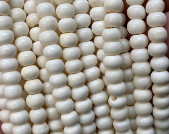 Peut inclure: Un brin de perles rondes en bois blanc. Les perles sont lisses et ont une couleur naturelle légèrement blanc cassé.