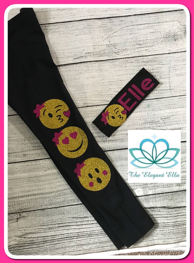 May include: Black leggings with three gold glitter smiley faces on the left leg. A pink glitter headband with the name "Elle" is included.