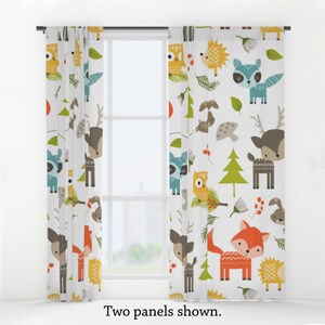 May include: Two white curtain panels featuring a woodland animal print. The print includes deer, foxes, owls, raccoons, hedgehogs, and trees in shades of orange, green, blue, brown, and yellow.