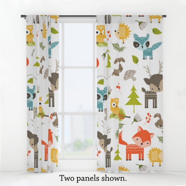 May include: Two white curtain panels featuring a woodland animal print. The print includes deer, foxes, owls, raccoons, hedgehogs, and trees in shades of orange, green, blue, brown, and yellow.