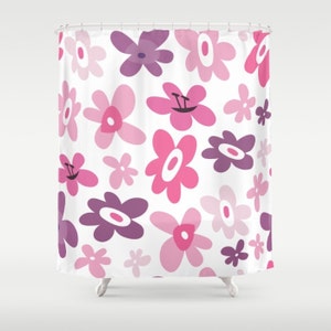 May include: A shower curtain with a white background and a pattern of pink and purple flowers. The flowers are all different shapes and sizes, and some have a smiley face in the center.