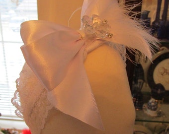 Double satin bow with feather and bling on a stretchy lace headband to match Jessica gown