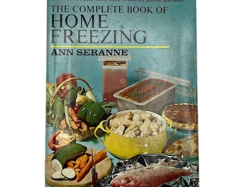 May include: A vintage cookbook titled "THE COMPLETE BOOK OF HOME FREEZING" by Ann Seranne. The cover is teal with images of frozen food and fresh produce. The book promises a new approach to home freezing.