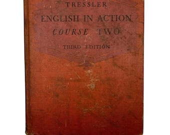 May include: A vintage, well-worn book with a faded orange cover. The title "English in Action Course Two" is printed in dark red within a diamond-shaped design. The book is a third edition, showing signs of age and use.