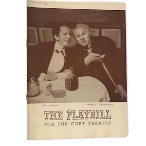 Könnte beinhalten: Ein Schwarzweißfoto von zwei Männern, die an einem Tisch sitzen. Beide Männer tragen Anzüge und Krawatten. Der Mann links schaut den Mann rechts an, der mit seiner rechten Hand zeigt. Der Text "THE PLAYBILL FOR THE CORT THEATRE" ist in Schwarz auf weißem Hintergrund gedruckt.