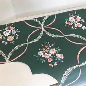 Puede incluir: Papel tapiz verde con un patr&oacute;n de encaje blanco y acentos de cinta rosa. El papel tapiz presenta un dise&ntilde;o floral con flores rosas, blancas y azules.