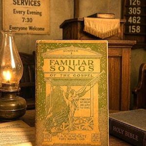 May include: A vintage book titled Familiar Songs of the Gospel Number 1 with a green and tan cover featuring an illustration of an angel blowing a trumpet. The book includes the text Songs That We Know and Love to Sing and Published by E.A.K. Hackett.